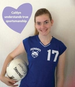 Caitlyn in a blue volleyball jersey holding a volleyball.