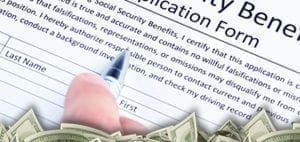 Hand filling out a Social Security Benefits Application Form with money at the bottom.
