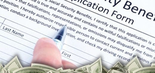 Hand filling out a Social Security Benefits Application Form with money at the bottom.