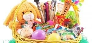Easter basket filled with candy, a plush bunny, and plastic eggs.
