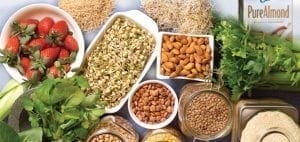 Assortment of gluten-free and casein-free foods including strawberries, sprouts, almonds, lentils, and almond milk.