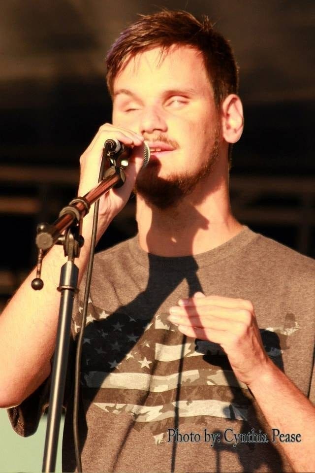 Jordan Obrecht singing into a microphone.