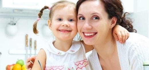 Mother and daughter smiling in a kitchen.