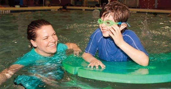 A woman and a child in a swimming pool.