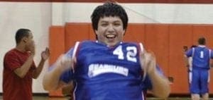 Dallas, wearing a blue basketball jersey with the number 42, smiles broadly.