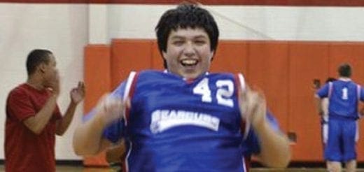 Dallas, wearing a blue basketball jersey with the number 42, smiles broadly.