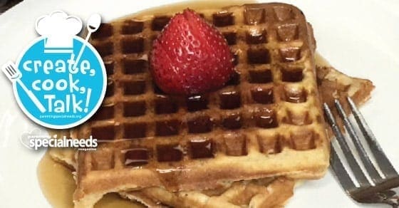 Waffles topped with syrup and a strawberry