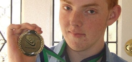 Jake holding up a "Junior Sportsman of the Year" medal.