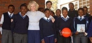 Eunice Kennedy Shriver with students and a man behind her.