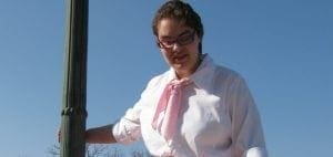 Angela wearing a white shirt and pink scarf.
