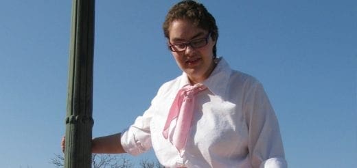 Angela wearing a white shirt and pink scarf.