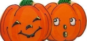 Two pumpkin-shaped cookies with icing faces.