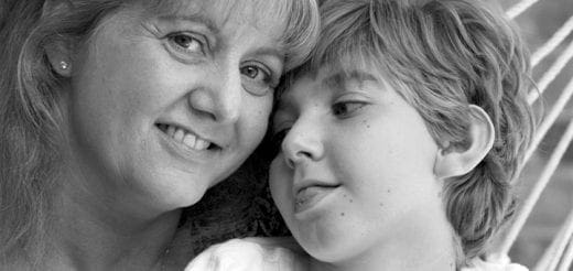 A woman and a child with their foreheads touching.