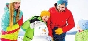 Family building a snowman in the snow.