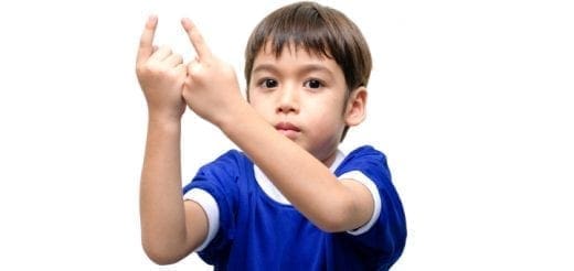 Child in a blue shirt holding up two fingers