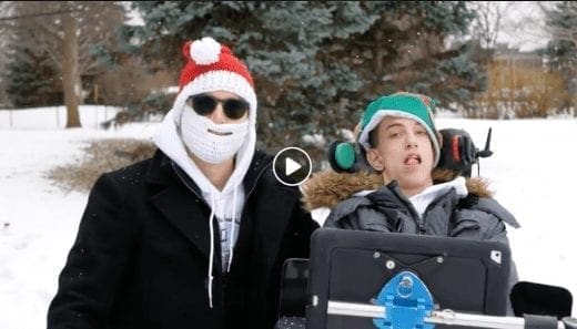 Two people in winter hats and coats stand in the snow.