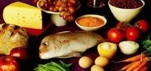 Assortment of healthy foods including cheese, bread, fish, eggs, fruits, and vegetables.