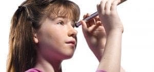 Young girl looking through a telescope.