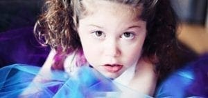 Emily with curly hair and a purple and blue overlay.