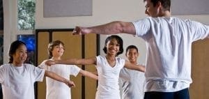 Instructor leading a physical education class with four students.
