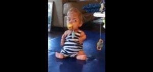 Samuel sitting on the floor with a pacifier.