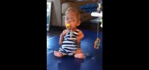Samuel sitting on the floor with a pacifier.
