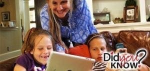 Three children and a woman look at a tablet computer.