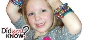 Girl wearing colorful bracelets smiles with arms behind her head.