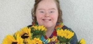 Amber smiles with sunflowers and a lei.