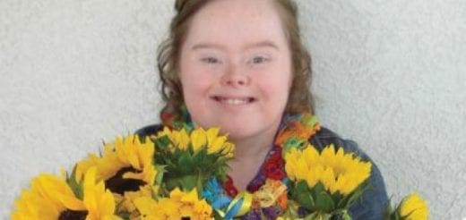 Amber smiles with sunflowers and a lei.