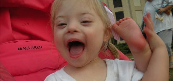 Auriana with her mouth open and feet in the air