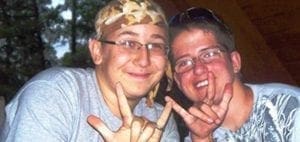 Two friends smiling and making hand gestures.