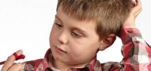 Child with red tape on finger looking away