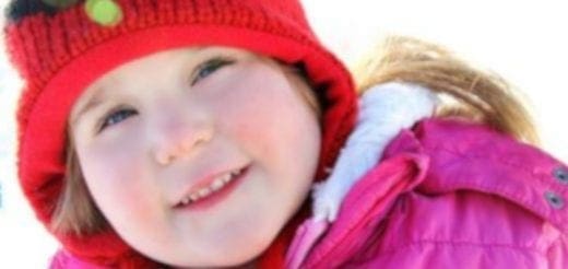 Cheyenne Emily wearing a red hat and pink coat.
