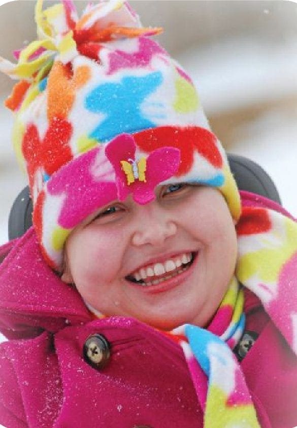 Cortney Kovack smiling in a colorful winter hat and scarf.