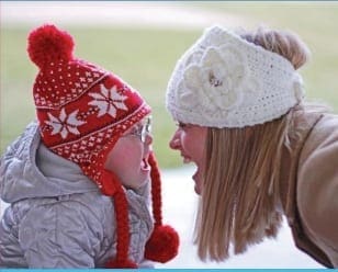 Two people in winter hats facing each other and shouting.