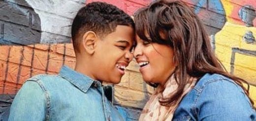 Mary and Justin touching foreheads and laughing in front of a graffiti-covered wall.