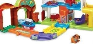 A colorful toy house with a small dog figurine.