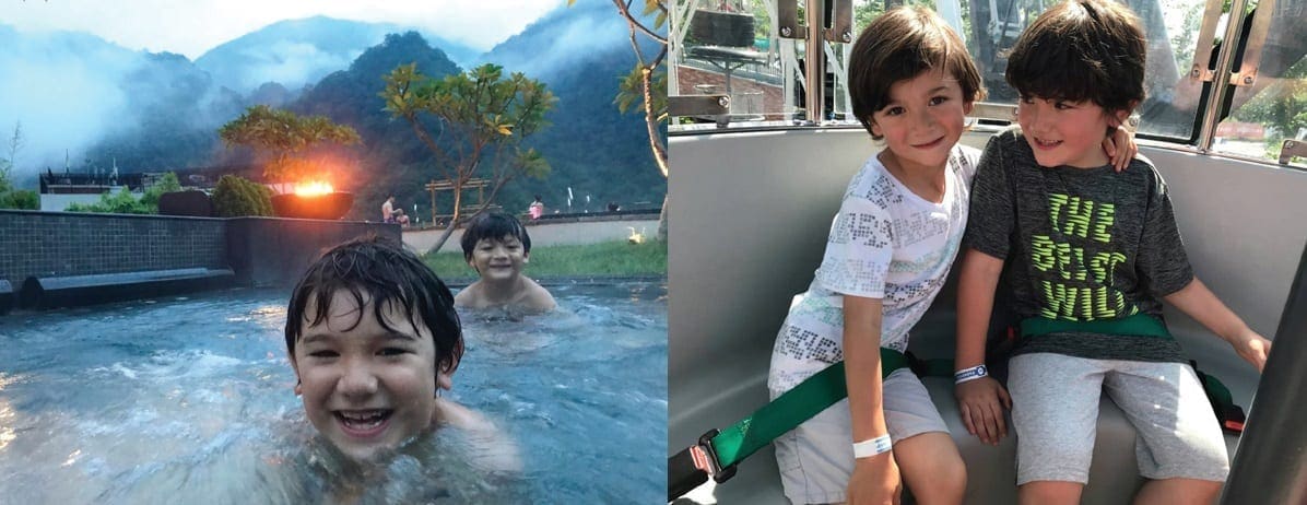 Two children enjoy a hot spring with mountains in the background and two children in a vehicle.