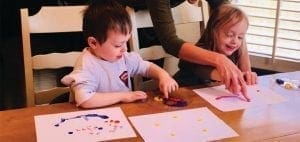 Two children painting at a table.
