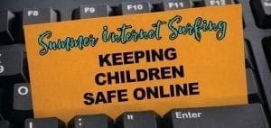 Orange note on a black computer keyboard reading Summer Internet Surfing Keeping Children Safe Online.