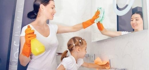 Mother and daughter cleaning a mirror and counter