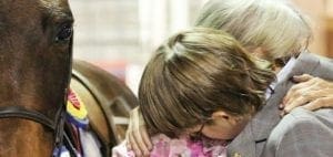 Kathy, Evan and Nikki the horse embracing.