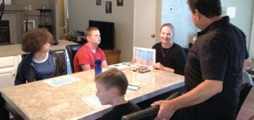 Family members gathered around a table, discussing behavior support.