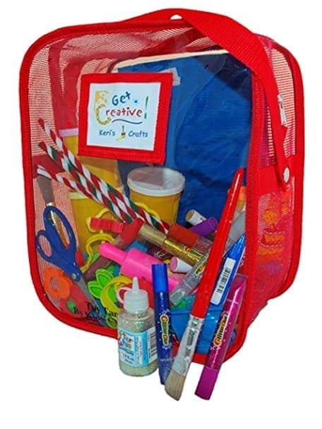 Red mesh bag filled with art supplies including scissors, crayons, paint, and craft sticks.