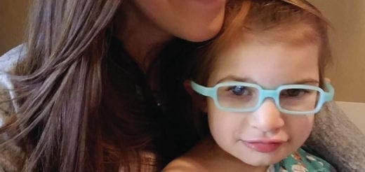 Kimberly embracing Finley who is wearing light-colored glasses.