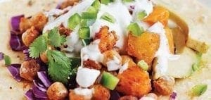 Chickpea and butternut squash tacos topped with crema, cilantro, and jalapeños.