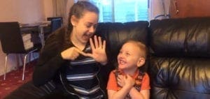 Christian and Jade signing possibilities while smiling on a couch.