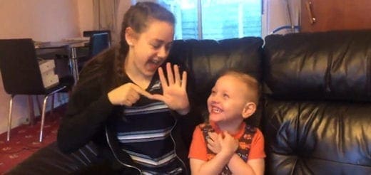 Christian and Jade signing possibilities while smiling on a couch.