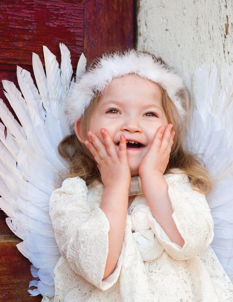 Savannah Rose Richardson with her hands on her cheeks, wearing angel wings.